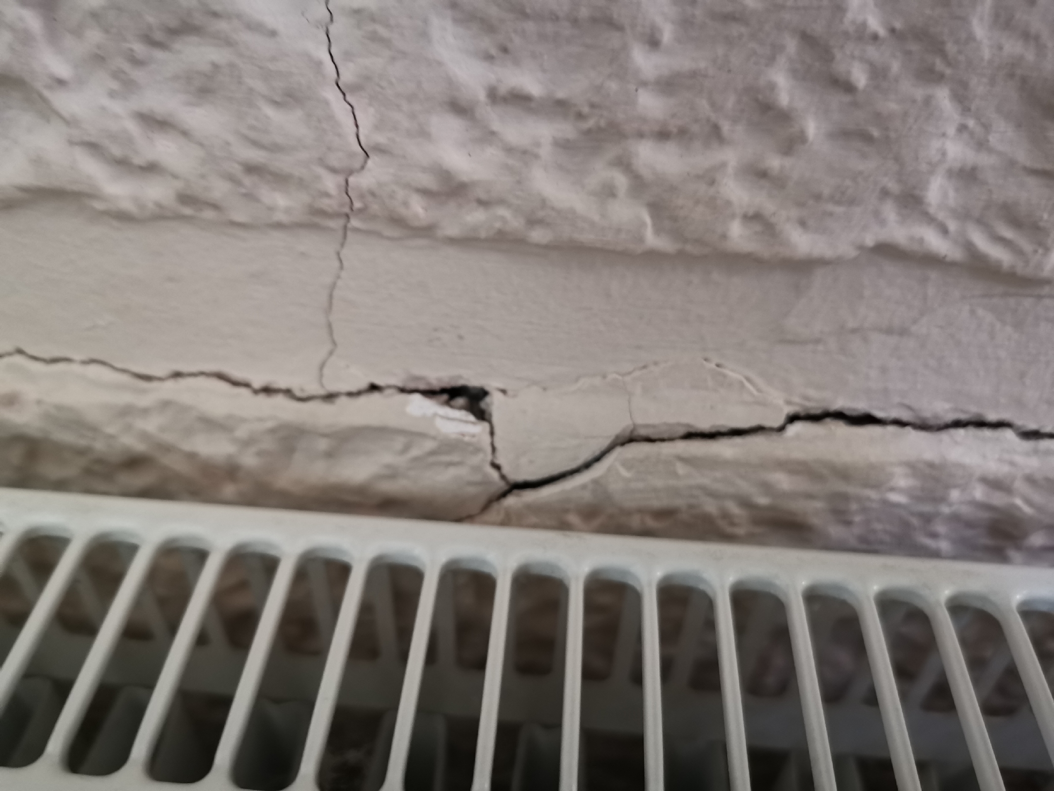 Blown chrysolite plaster behind radiator